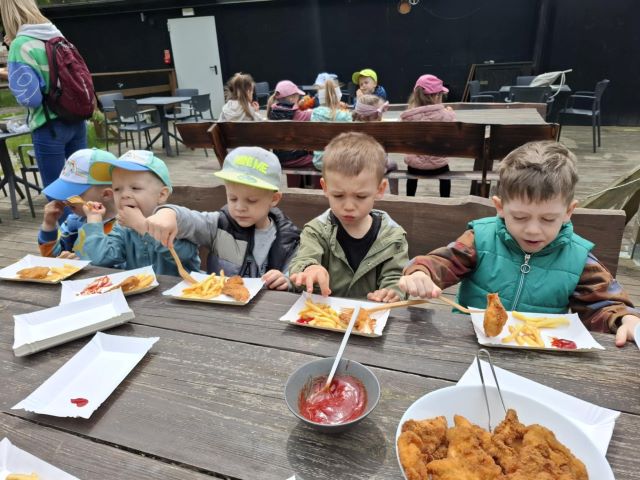 dzieci jedza frytki i nagetsy