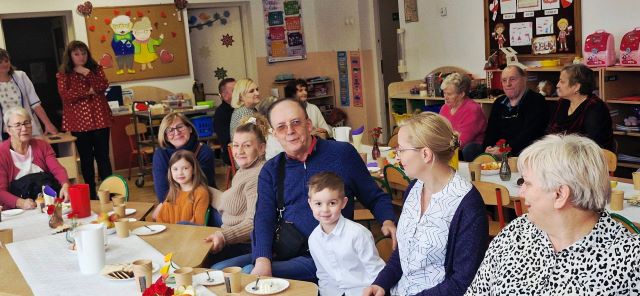 dzieckowie i babcie siedza przy stolikach