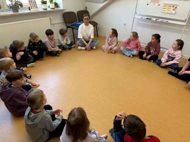 dzieci siedza w kole na podlodze