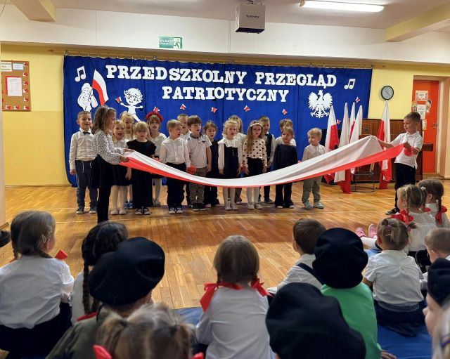 dzieci spiewaja i trzymaja flage